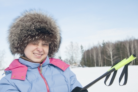 Woman tourist skier in snowy forest with ski polesの写真素材