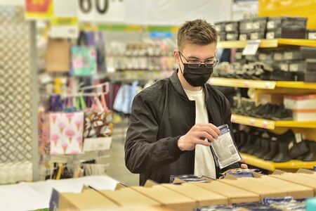 Man with face mask shopping for groceriesの写真素材