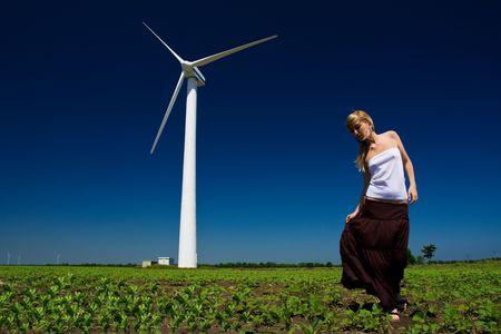 Model posing in front of wind power generatorの写真素材