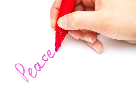 Kid writing peace on white paper with red colorの写真素材