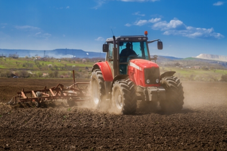 Brand new red tractor on the field workingの写真素材