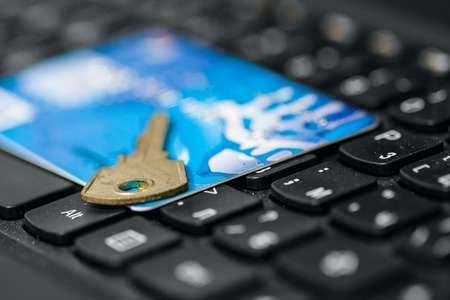 Key and credit card on keyboardの写真素材