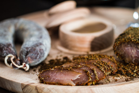 Meat fillet and sausage on cutting wooden plateauの写真素材