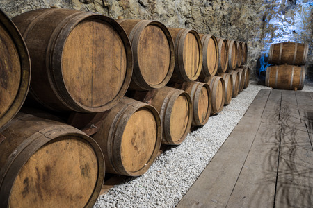 An old wine cellar with oak barrels full of red wine