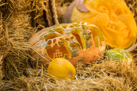Helloween pumpkin on hay at old wooden farm houseの写真素材