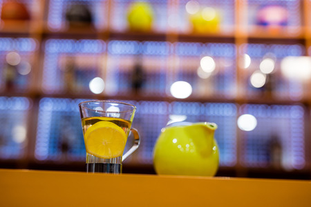 Cup of tea and kettle on table in barの写真素材
