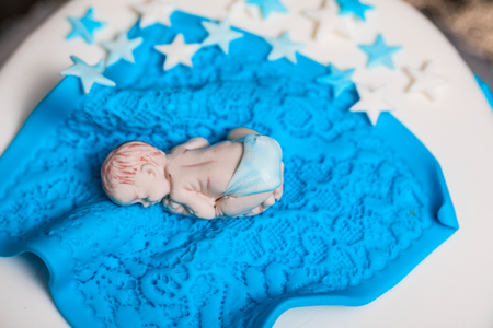 Birthday cake for baby with small sugar baby on itの写真素材