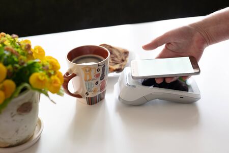 Contactless payment through mobile cell phone at cafe.