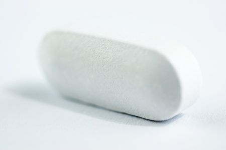 Macro view of  white pill isolated on white background.の写真素材