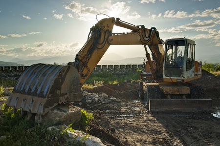 Excavator located by a river and ready for work