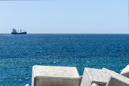 Breakwater blocks in the port of Barcelona, Catalonia, with a boat in the background