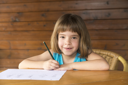 Little girl sitting and drawing on a terrace の写真素材