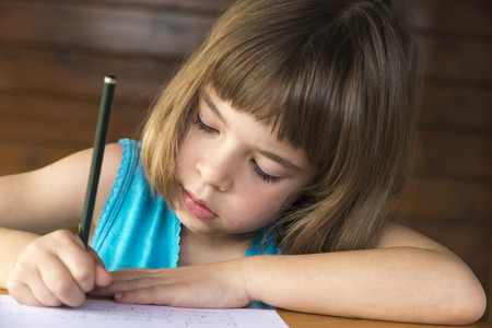 Little girl sitting and drawing on a terrace の写真素材