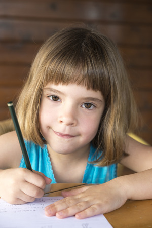 Little girl sitting and drawing on a terrace の写真素材