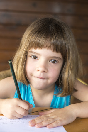 Little girl sitting and drawing on a terrace の写真素材