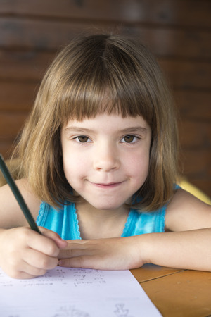 Little girl sitting and drawing on a terrace の写真素材