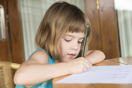 Little girl sitting and drawing on a terrace の写真素材