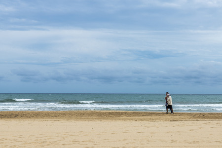 Tarragona, Spain - 24 May, 2014  Two women walking along an empty beach while they converse in Costa Daurada, Tarragona, Catalonia, Spain のeditorial素材