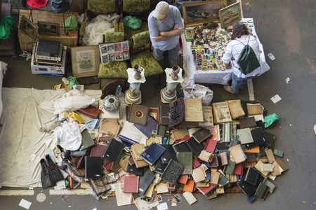 Barcelona, Spain - June 18, 2014   Seller at his post of objects and furniture resale while a client is looking for something to buy in the most famous flea market in Barcelona, also known as Els Encants or Els Encants Vells, located in Glories neighborhoのeditorial素材