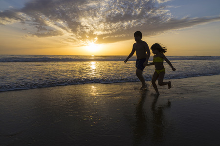 Children bathing on the beach at dusk on a beach in Andalusia, Spainの写真素材