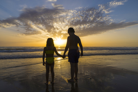 Children bathing on the beach at dusk in Andalusia, Spainの写真素材