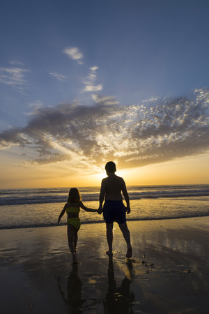Children bathing on the beach at dusk in Andalusia, Spainの写真素材