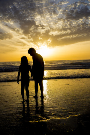 Children bathing on the beach at dusk in Andalusia, Spainの写真素材