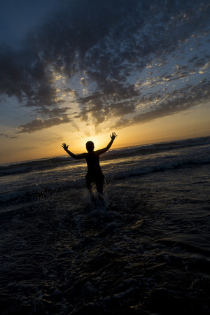 boy bathing on the beach at dusk on a beach in Andalusia, Spainの写真素材