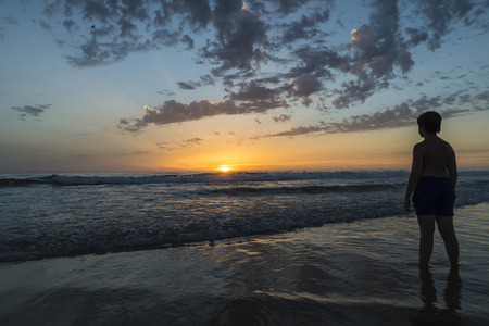 boy bathing on the beach at dusk on a beach in Andalusia, Spainの写真素材