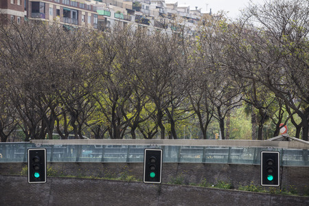 three green lights in a square in Barcelonaの写真素材