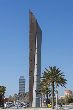 Barcelona, Spain - April 9, 2014: modern obelisk-shaped structure on the seafront of Barcelona.  In the background is the Mapfre tower.のeditorial素材