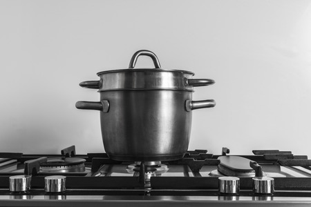 A pot over a kitchen stove.の写真素材