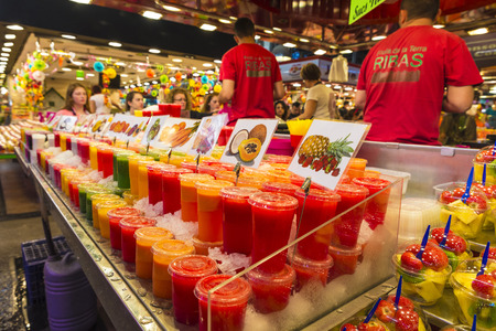 Barcelona, Spain - October 17, 2014: Fruit stand with chopped fruit and smoothies ready to take on the market of La Boqueria. Vendors are responding to their numerous customersのeditorial素材