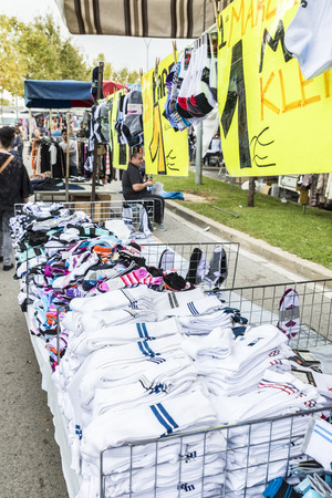 Badalona, Spain - November 1, 2014: Stall clothes in the market Turo Caritg in Badalona, a town next to Barcelona. The vendors serve customers while they choose and seek something you likeのeditorial素材