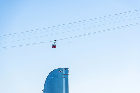 Barcelona, Spain - October 22, 2014: Funicular and plane over the W hotel in Port VellPort Vell is a main attraction in Barcelona. Barcelona is a vibrant modern city at the Mediterranean with lots of attractionsのeditorial素材