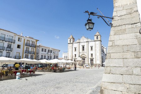 Evora, Portugal - August 21, 2014: Giraldo Square in center of Evora. The square dates from 1570 and features the Renaissance fountain (fonte Henriquina) and the St Anton Church. In this square many terraces of bars where people having a drink in the shadのeditorial素材