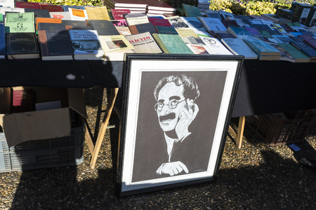 Girona, Spain - December 28, 2014: Objects used, furniture, artwork and ornaments on a market stall in the flea market in Girona, also known as Mercat de la Lleona. This image highlights a drawing of Groucho Marxのeditorial素材