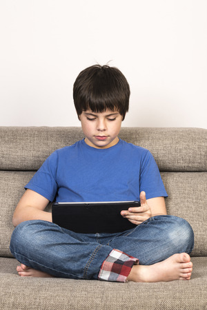 Young boy using tablet digital on the sofa.の写真素材