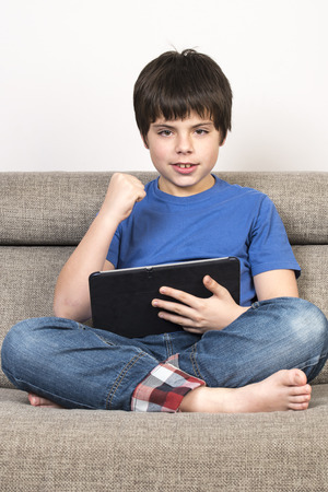 Young boy using tablet digital on the sofa.の写真素材