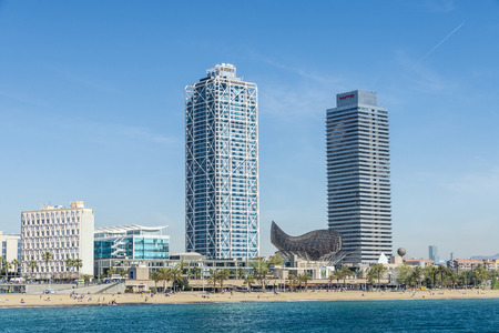 Barcelona, Spain - April 7, 2014: Barceloneta Beach with Hotel Arts, Mapfre tower, several restaurants, the goldfish of Frank Gehry with several swimmers.のeditorial素材