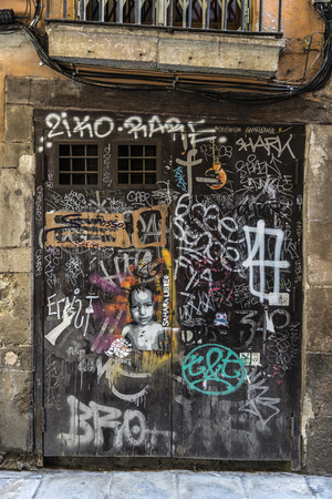 Barcelona, Spain - April 7, 2014: Door covered with graffiti in the old town of Barcelona, Catalonia, Spainのeditorial素材