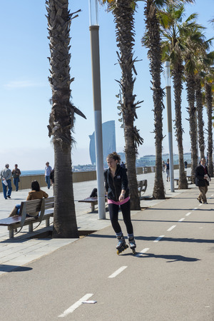 Barcelona, Spain - April 7, 2014: Girl skating on the promenade to Barceloneta beachのeditorial素材