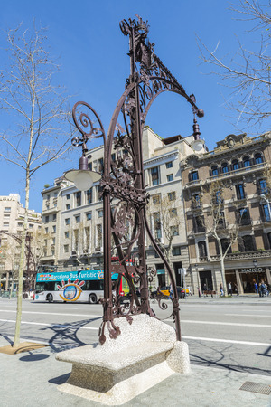 Barcelona, Spain - March 27, 2015: Bench and lamppost Modernist style one-piece built in 1906 and recently restored on the Passeig de Gracia. The bench is made with a technique called trencadis. In the background, a tourist bus passesのeditorial素材