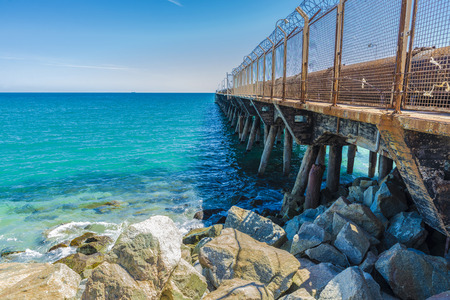 Industrial jetty protected with barbed wire to prevent passage in Barcelona, Catalonia, Spainの写真素材