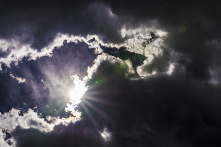 Dramatic sky with the sun beaming among the clouds. Natural background.の写真素材