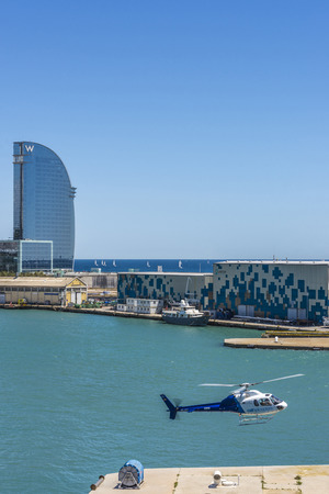 Barcelona, Spain - May 23, 2014: Helicopter landing with the W hotel in the background in the port of Barcelonaのeditorial素材