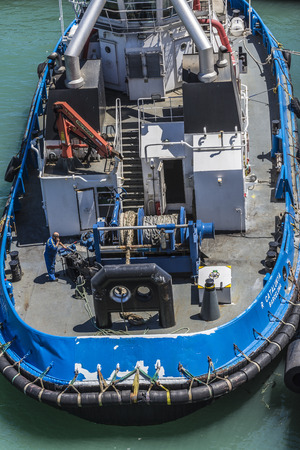 Barcelona, Spain - May 23, 2014: Deck of a ship with coils of chains and ropes tied in a harbor with a man working on maintenanceのeditorial素材