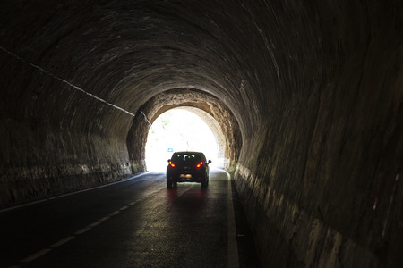 Car running through an old tunnel with galleries through which light enters in Spainの写真素材