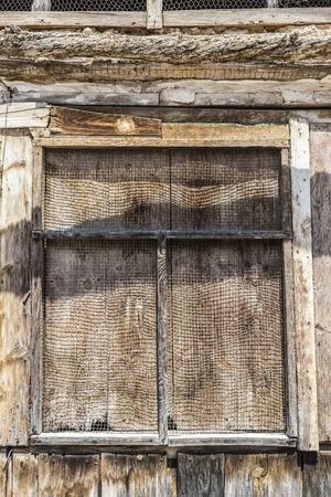Old wooden window covered with a metal grate in Spainの写真素材