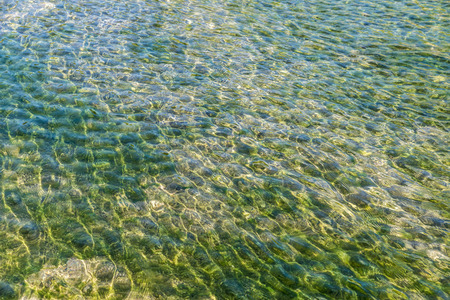 Clean and calm water of a river with rocks and stones as background